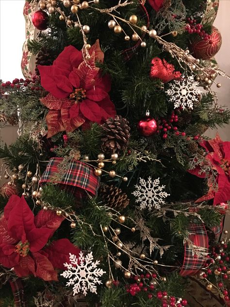 Traditional Christmas tree with poinsettias, red berries, snowflakes, pine cones and plaid ribbon Christmas Tree With Red Berries And Pine Cones, Christmas Tree Red Poinsettia, Red Poinsettia Christmas Decor, Poinsettia In Christmas Tree, Poinsettias On Christmas Tree, Poinsettia Christmas Tree Decorations, Red Poinsettia Christmas Tree, Red Tartan Christmas Tree, Christmas Tree With Poinsettia Flowers