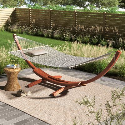 With its unique shape and design, this double hammock with tand provides you with ultimate comfort and relaxation so you can unwind from a busy day. Made of beautifully finished hardwood, this stand is the perfect aesthetic addition to your outdoor living space. Soak up the sun and kick up your feet while getting some shut-eye with this sleek hammock stand. Hammock Wood, Stand Alone Hammock, Wooden Hammock Stand, Wooden Hammock, Double Hammock With Stand, Chill Spot, Patio Hammock, Hammock With Stand, Perfect Aesthetic