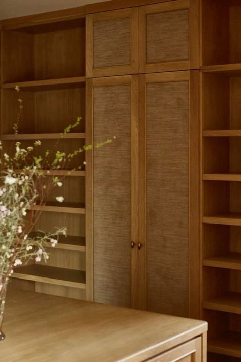 Image of elegant wooden bookshelves with built-in storage, showcasing a natural wood finish and minimalistic design. A vase with flowers is placed in the foreground, adding a touch of nature to the sophisticated setting. Wood Panel Bookshelves, Natural Wood Closet, Timber Bookshelf, Wood Built Ins, Wooden Bookshelves, Dining Room Shelves, Wooden Closet, Books Decor, Timber Veneer