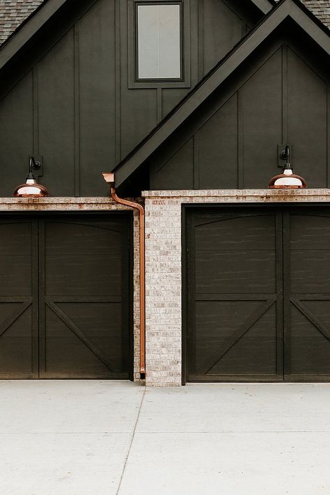 From the chic pendants hanging over your kitchen island to the chandelier in your master bedroom, you've got this lighting thing down pat. But — have you thought about exterior house lights? If not, you definitely should. #hunkerhome #lighting #exterior #exteriorlighting #lightingideas Exterior House Lights, Black Garage Door, Black Garage Doors, Black Garage, Board And Batten Exterior, Black Houses, Light Brick, Dark Modern, Modern Garage