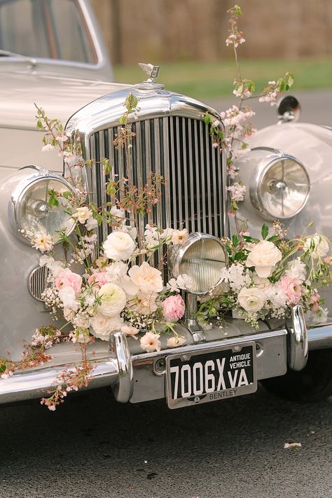 Vintage car decorated with cherry blossoms and flowers for gorgeous wedding photo ideas Flower On Car Wedding, Car Floral Decor, Vintage Car Flower Decor, Vintage Cars For Wedding, White Convertible Wedding Car, Vintage Car Floral Installation, Cars Wedding Decoration, Vintage Car For Wedding, Wedding Cars Vintage