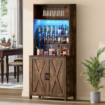 Our farmhouse bar cabinet is a versatile all-in-one solution. It features adjustable LED lights in over 7 colours, beautifully showcasing your wines and glassware in any room. The left side offers four beverage dispensers for various bottles, while the right side has secure shelves and a glass rack. This tall cabinet combines a wine rack, glass rack, beverage dispenser, and storage, suitable for a coffee bar, kitchen storage, or buffet. Crafted from high-quality materials, it ensures stability a Cabinet With Wine Rack, Wine Rack Shelf, Wood Bar Cabinet, Basement Bar Design, Rack Shelves, Kitchen Storage Cabinet, Farmhouse Bar, Doors Kitchen, Farmhouse Cabinets