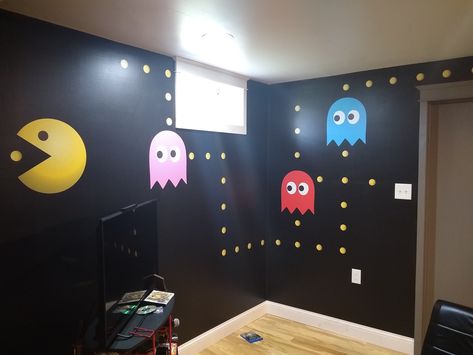 Video Game Room. I painted the black wall with Behr Marquee paint. I'm a little old school, so I added pac man for a little fun and color. www.allisrealtors.com Game Room Feature Wall Ideas, Wall Tiles Game Room, Old School Game Room, Video Game Room Paint Ideas, Gaming Wall Painting, Game Wall Ideas, Black Wall Game Room, Video Game Room Decor Diy, Gamer Accent Wall