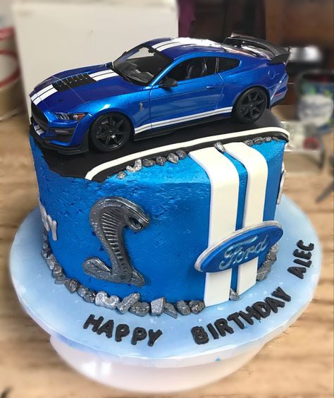 I made this cake for my son’s 11th birthday. This is his favorite car and wanted a cake to refect his live for this car. I made it into a 3 layer caje 10 inches in diameter. It is frosted with homemade buttercream and I put pie filling in between the cake layers. I frosted the cake in blue and then airbrushed a metalic blue food dye onto the fristing to give it a sheen. The decoations were all done in fondant. The car in top was purchase and is a 1:18 scale diecast mustang. Muscle Car Cakes For Men, Mustang Cars Birthday Cake, Race Car Birthday Cake For Men, Ford Mustang Cakes For Men, Car Cakes Design, Mustang Theme Birthday Party, Mustang Car Cake, Blue Car Birthday Cake, Mustang Cakes For Men