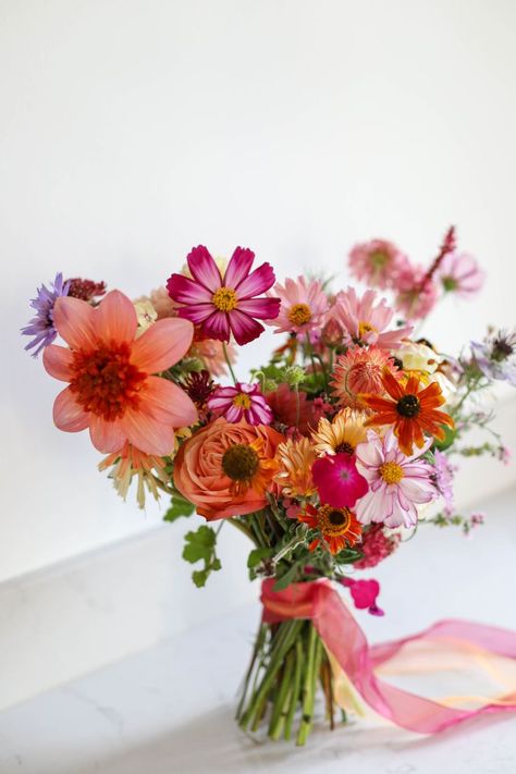 Colourful natural bridal bouquet sits on a marble sideboard Dahlia Bridal Bouquet, Bright Wedding Bouquet, Natural Bouquet Wedding, Summer Bridal Bouquet, Wildflower Bridal Bouquets, Orange Bridal Bouquet, Orange Wedding Bouquet, Orange And Pink Wedding, Colorful Bridal Bouquet