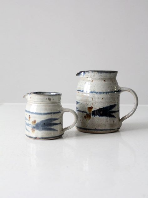 This is a pair of vintage English studio pitchers.  Signed by the artist, the handmade small ewer pair features a lovely white and blue glaze.  An ideal serving size for syrups, gravies, creams, and also wonderful as decorative vases. CONDITION In good condition with wear consistent with age and use.  MEASUREMENTS LARGE Height: 5.75"  ..  14.6 cm Width:  5.875"  .. 14.9 cm Depth: 4.25"  ..  10.8 cm SMALL Height:  3.75"  ..  9.5 cm Width:  4.75"  ..  12.1 cm Depth: 3.25"  ..  8.3 cm 102368 Pottery Place, Coffee Table Trunk, Vintage Ceramics, Decorative Vases, Pitcher Set, Pendant Light Shades, Woven Baskets Storage, Surface Decoration, Decanter Set