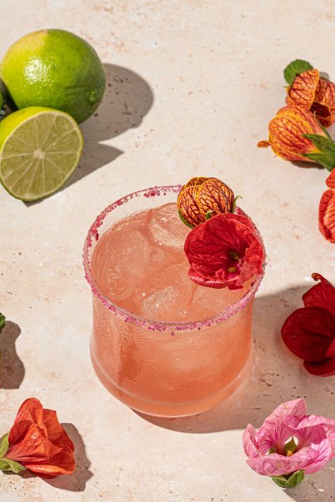 This refreshing floral cocktail is a twist on the classic margarita with the addition of a simple hibiscus syrup. Wild Flower Party Food, Hibiscus Margarita Recipe, Thumbelina Wedding, Botanical Drinks, Floral Margarita, Flower Cocktails, Flower Drinks, Floral Drinks, Hibiscus Margarita