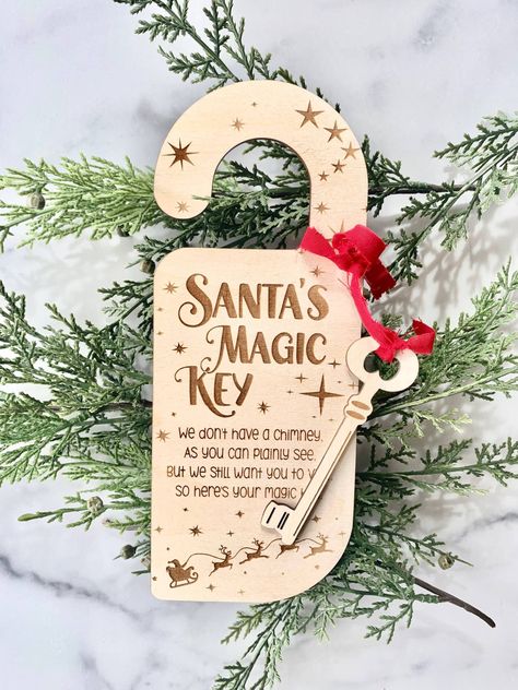 "Santa's Magic Key Door Hanger Ornament Don't have a Chimney for Santa? No worries! The Kids Will Have Fun Hanging our Magic Key Door Hanger up For Santa So He has a Key to get in and Leave Their Presents Under The Tree! Laser Engraved on 1/8\" Baltic Birch with Ribbon. * Measures approx 9\" long and key attached is approx 4\" long * Hanger and Key are cut from 1/8\" Baltic Birch * All products are made and shipped from our small business in Savannah, GA * Due to the handmade nature of our sign, Santa’s Magic Key Door Hanger, Craft Fair Christmas Ideas, Small Business Christmas Ideas, Laser Cut Christmas Ideas, Laser Christmas Ideas, Christmas Lasercut, Santa Magic Key, Santas Magic Key, Laser Engraved Christmas