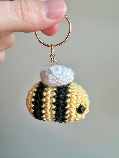 🐝 Bring a touch of whimsy to your daily essentials with this adorable crochet bee keychain!  🍯 This little bee makes a thoughtful and heartwarming present for birthdays, holidays, or the random Tuesday! Treat yourself or surprise a friend with this adorable accessory! Crochet Bee Keychain, Bee Keychain, Bee Hat, Bee Free, Handmade Plushies, Crochet Bee, Keychain Handmade, Adorable Crochet, Crochet Keychain