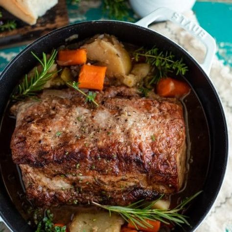 Tender and juicy, this Dutch Oven Pork Roast transforms an affordable cut of meat into a delicious comfort food dinner. The pork loin slowly bakes in an apple cider broth with potatoes, carrots, celery, onion and herbs. A quick pan gravy adds the perfect finishing touch on the one pot meal. Serve this simple boneless pork roast recipe with a side of flaky buttermilk biscuits or a pan of cornbread for your next cozy Sunday supper! Dutch Oven Pork Roast, Oven Pork Roast, Roast In Dutch Oven, Pork Roast With Gravy, Dutch Oven Pork, Boneless Pork Loin Recipes, Pork Pot Roast, Pork Sirloin Roast, Boneless Pork Loin Roast