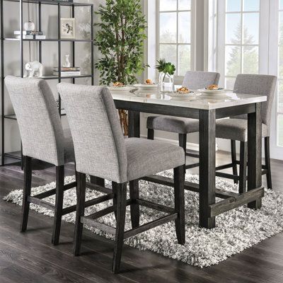 Elevate your dining area with this rustic counter height dining set. The rectangular table is supported on a solid wood framework with square legs. Cross braces provide stability and footrests for extra comfort. Set includes four side chairs, all plushy upholstered in light grey linen-look fabric. The table surface is crafted from white genuine marble and contrasts strikingly with the antique black finish for an elegant and eye-catching addition to your home. Grey Kitchen Table, Rustic Dining Room Sets, Counter Height Dining Table Set, Dinning Table Set, Dining Table Height, Rustic Counter, Farmhouse Chairs, Table Surface, Counter Height Dining Table