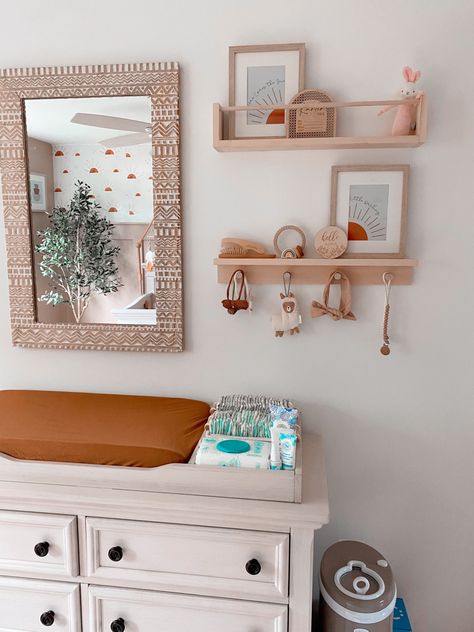 Beige and rust baby girl nursery with peg shelves and changing table Wall Decor Over Changing Table, Boho Nursery Changing Tables, Changing Area Nursery, Nursery Shelves Above Changing Table, Shelf Above Changing Table, Mirror Over Changing Table, Girl Nursery Changing Table, Changing Table Wall Decor, Above Changing Table Decor