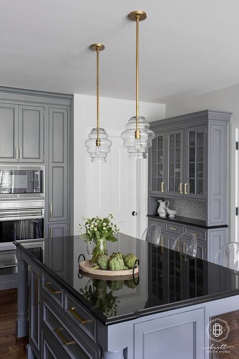 Gray kitchen island featuring a black quartz countertop under a set of mini glass and brass lanterns fitted with ghost counter stools. Black Quartz Countertop, Gray Kitchen Island, Kitchen Black Counter, Black And Grey Kitchen, Gray Cabinet, Black Kitchen Countertops, Grey Kitchen Island, Grey Kitchen Designs, Black Countertops