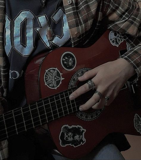 a hand on a guitar Flannel Dark Academia, Wooden Guitar Aesthetic, Dark Musical Aesthetic, Acoustic Guitar Grunge, Dark Academia Instrument, Flannel Grunge Aesthetic, Rock Men Aesthetic, Punk Guitar Aesthetic, Lead Guitar Aesthetic