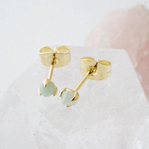 A pair of delicately set, tiny jade crystal stud earrings. Gorgeous when worn alone or alongside your favorite studs. Jade is a gemstone known for manifesting and creating wealth and balance. These measure in at a tiny 3 mm. Our materials make for an amazing, high quality, seamless, jewelry piece with longevity. Our earrings are plated with 18k gold, 18k rose gold, or rhodium and finished with a protective coating. A little secret we'll keep between us: it looks way more than it costs. Delicate Gold Jewelry, Creating Wealth, Daisy Studs, Jade Crystal, Bar Studs, Solitaire Studs, Between Us, Crystal Stud Earrings, Delicate Jewelry