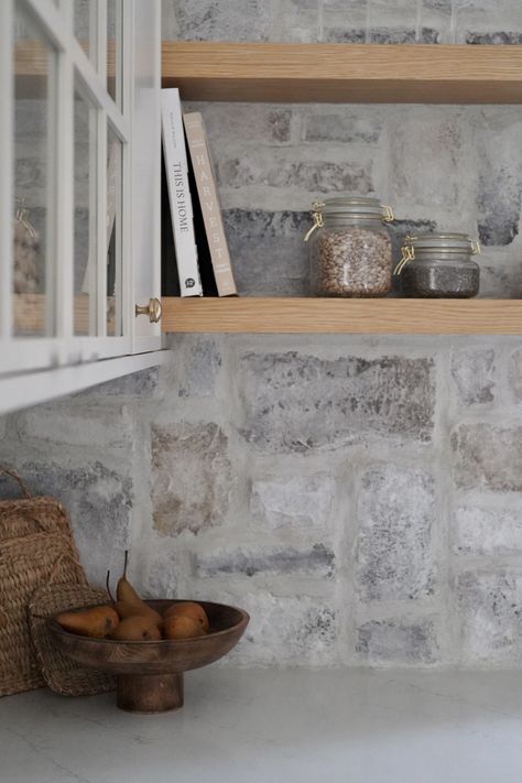 Drawing inspiration from the natural surroundings, we incorporated a stunning natural limestone backsplash around the sink, infusing the space with visual intrigue and timeless charm. Cottage Kitchen Stone Backsplash, Limestone Backsplash Kitchen, Natural Stone Backsplash Kitchen, Stone Veneer Backsplash, Full Kitchen Design, Limestone Backsplash, Kitchen Stone Wall, Stone Kitchen Backsplash, Farmhouse Kitchen Renovation