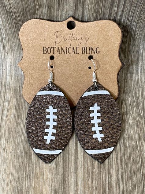 With fall comes football season!  show your love for football with these adorable football earrings!  They are made with faux leather and detailed with white HTV.  They are lightweight but sturdy.  They are made to order so please allow a few days for production before being shipped. Please note that I do not accept returns as my items are made to order. Additionally, due to sanitary reasons with piercing jewelry, returns are not accepted. However, if you encounter any issues with your order, pl Football Earrings, Football Season, Piercing Jewelry, Jewelry Earrings Dangle, Dangle Drop Earrings, Dangle Earrings, Faux Leather, Accessory Gift, Jewelry Earrings