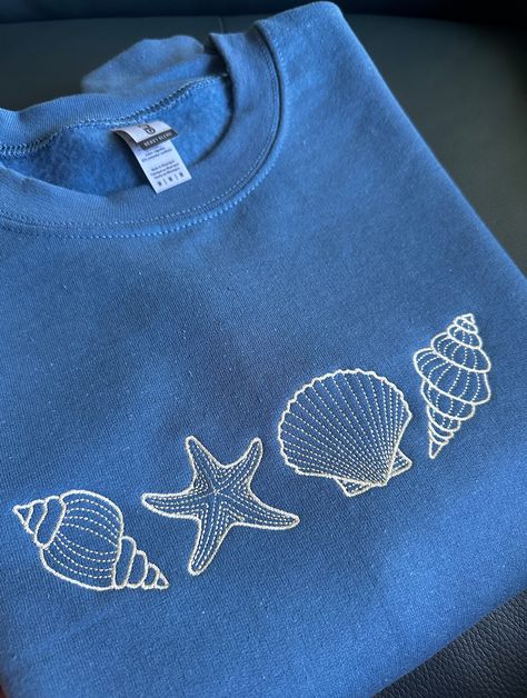 Perfect for a seaside trip, or throwing it on after a beach day! Cute embroidered seashell sweatshirt a great addition to your closet.  Custom Available:  - Size can be made bigger if required, please reach out to us - different color sweatshirts available, Crewnecks & Hoodies - different thread colors available  If you would like to purchase multiple sweatshirts or a different color or a change in design, please contact me first!  All requests are welcome! Sizing : These sweatshirts are in ADUL Embroidery Designs For Tshirts, Graphic Designs For Shirts, Seashell Clothes, How To Embroider By Hand On Clothes, Embroidery Designs Shirt, Embroidery Designs Tshirt, Simple Sweatshirt Design, Embroidery Designs Sweatshirt, Embroidery Sweatshirt Ideas