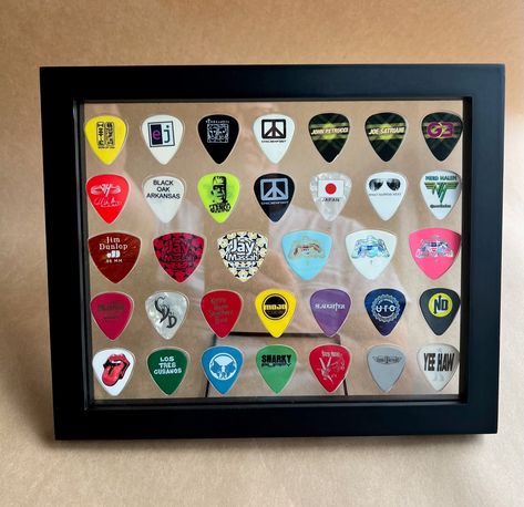 "Plectrum Spectrum™ Guitar Pick Displays are the perfect gift for the guitarist/music enthusiast in your life. Hang in your music room, place on top of your amp, or simply hang on any wall. Do you have a favorite band?  Display all those hard to catch picks from concerts the right wayFOR ALL TO SEE!  The display you see here holds 28 regular guitar picks, and 6 rounded bass picks.  Each purchase includes a solid wood 8\" x 10\" double sided float frame (wall hangars, and stand provided), and acr Regular Guitar, Cool Guitar Picks, John Petrucci, Float Frame, Clear Frames, Back Pieces, Guitar Picks, Frame Wall, Music Room