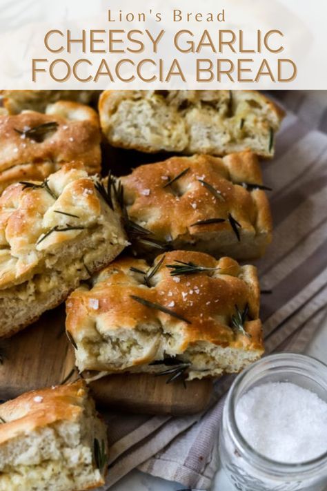 Sliced cheesy garlic rosemary focaccia bread on a wooden cutting board with flaky sea salt on the side with the words "Lion's bread cheesy garlic focaccia bread" in the foreground Herb And Cheese Focaccia, Garlic Foccia Bread, Parmesan Herb Focaccia, Cheese Focaccia Bread Recipe, Rosemary Garlic Sourdough Foccacia, Focaccia Bread Cheese, Sourdough Discard Garlic Focaccia, Cheesy Sourdough Focaccia, Cheesy Garlic Focaccia Bread