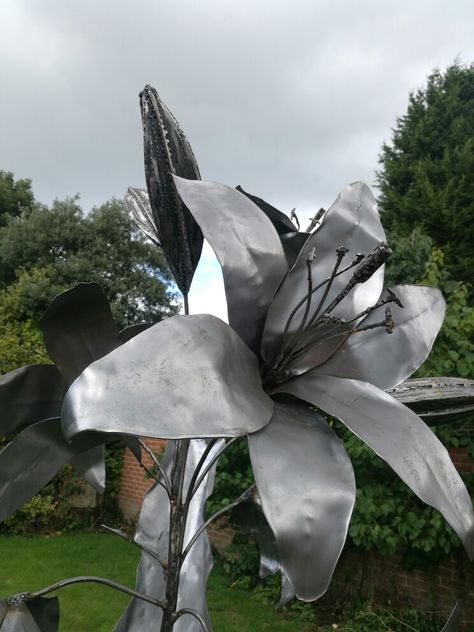 Derail of lily plant, metal sculpture. Recycled Garden Decor, Lily Plant, Boundary Wall, Welding Ideas, Clay Inspo, Welding Art Projects, Recycled Garden, Lily Plants, Flower Sculptures