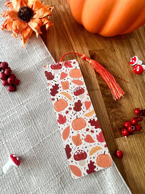 Autumn Leaves Bookmark, perfect for those cosy autumn evenings tuck up with a book! These cute bookmarks are printed on quality 400gsm cardstock, with a smooth Matt lamination. Details: - 148mm x 52mm - Rounded corners - Choice of with or without burnt orange tassel - Double sided print: back side has the mochiimakes logo on it - Smooth Matt Laminated Bookmark - Printed on high quality 400gsm Cardstock All bookmarks are shipped in board backed envelopes for extra protection. Fall Bookmarks Diy, Orange Bookmark, Leaves Bookmark, Fall Bookmarks, Halloween Plants, Cottagecore Halloween, Autumn Bookmark, Cosy Fall, Autumn Fair