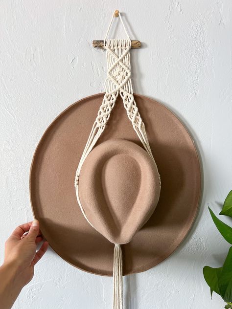 Display your favorite hats with a boho chic macrame hat holder! Handmade with central coast driftwood & natural cotton string. There are two different styles, a single tier & a double tier! Single Hat Hanger Dimensions The driftwood piece: 4 to 5" Length (with hat): approx. 32" Double Hat Hanger Dimensions The driftwood piece: 4 to 5" Length (with hats): approx. 46" Turnaround time + shipping Every hat hanger is handmade to order! Please allow for 3-5 business days before it ships off to you. Cu Macrame Boho Hat Hanger, Macrame Plate Hanger, Macrame Hat Holder Tutorial, Simple Macrame Hat Hanger, Hat Hanger Macrame, Macrame Cowboy Hat Holder Diy, Macrame Cowboy Hat Holder, Macrame Hat Hanger Diy, Diy Hat Holder