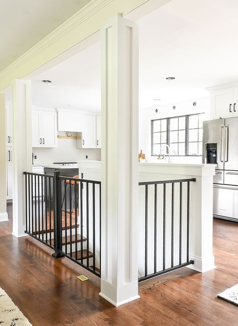 home with white craftsman style columns and black modern railing. #whitekitchen #ranchhome #rancher #craftsmancabinets #kitchendesign #openfloorplan #openconcept #openstairs Stairwell In Kitchen, Open Ranch Style Home, Stairs In Middle Of Kitchen, Remodel Open Floor Plan Before And After, Kitchen With Stairs In Middle, Open Floor Plan With Stairs In Middle, Kitchen With Stairs To Basement, Ranch House Open Basement Stairs, Small Ranch Renovation