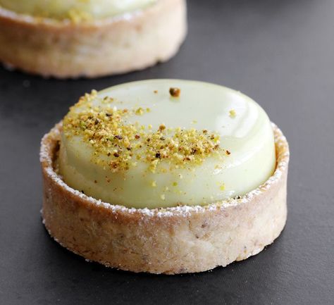 Oct 13, 2017 - If you like pistachios, you should really try this following pistachio tartelettes, which is pistachio heaven! Pistachio short crust pastry, filled with pistachio ganache and pistachio mousse, all topped with green glaze and chopped pistachios. This is a unique tartelette that pistachio lovers will absolutely adore, as… Pistachio Tartelette, Pistachio Tartlet, Napkin Doodles, Pistachio Tart, Patisserie Fine, Pistachio Butter, The Most Beautiful Pictures, Butter Milk, Slow Cooker Desserts