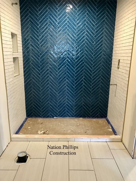 Beautiful peacock blue tile feature wall installed in a herringbone pattern. #anthologytile #watercolors #rustictile #blueherringbone Teal Herringbone Tile Bathroom, Blue Tile Accent Wall Bathroom, Blue Herringbone Shower Tile, Bathroom Blue Tile Wall, Navy Blue Herringbone Tile Bathroom, Navy Herringbone Tile Bathroom, Herringbone Accent Wall Bathroom, Tile Feature Wall Bathroom, Peacock Bathroom Ideas