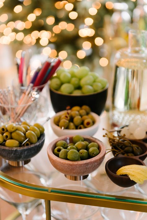 How to Set Up a Holiday Party Martini Bar - Front + Main Make Your Own Martini Bar Party Ideas, Holiday Bar Set Up, Holiday Party Bar Set Up, Martini Night Party, Cocktail Bar Set Up For Party, New Years Cocktail Party, Small Cocktail Party Ideas, Dirty Martini Party Decor, Martini Bar Set Up