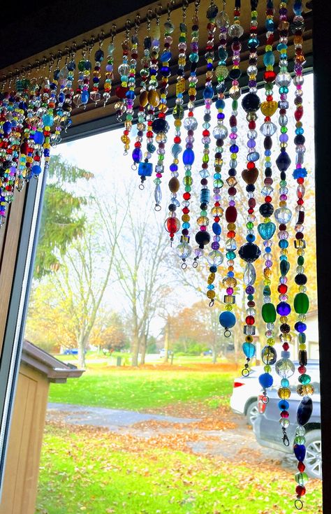 I make beaded valences as window treatments, beaded curtains for doors, beaded lamp shades, beaded garland for Christmas Trees and fireplace mantels, chandeliers, jewelry, almost anything you can imagine. A unique feature of my valance is that I have attached clasps to either end so individual strands can also be worn as jewelry (see photo of me wearing a part of my valence as a necklace)! Please let me know if you would like to customize your piece by color, strand length, etc, based on the size of your window or door, and for your Christmas tree too! I have found that beaded garlands are easier to drape on a tree or mantel due to the weight of the glass beads. They shimmer by day when the sun hits them and at night when the tree is lighted. My bead creations are bright and colorful. They Glass Bead Window, Beaded Lamp Shades, Curtains For Doors, Beaded Curtains Diy, Beaded Door Curtains, Christmas Tree And Fireplace, Glass Bead Crafts, Beaded Lampshade, Beaded Lamps