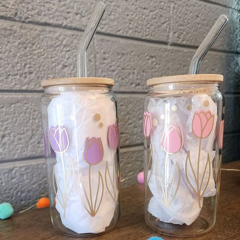 These are 16 oz libby beer can glass cups. They come with bamboo lids and glass straws. stems are made with gold vinyl, the variation you choose will be the flower color. Color changing colors are light pink to dark, light blue to dark and light green to dark. These are made with permanent vinyl and are handwash only.  Do not soak, do not microwave. Cute Cup Vinyl Designs, Glass Can Cups Vinyl, Cute Glass Cup Designs, Libby Cup Designs, Cricut Glass Cups, Vinyl Cup Ideas, Cricut Cup Ideas Vinyls, Glass Cups With Vinyl, Cute Glass Cups