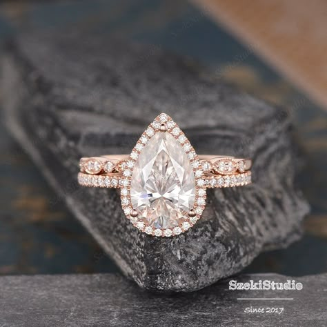 "3.5ct Pear Cut Moissanite Engagement Ring Set Pear Shaped Wedding Ring Rose Gold Bridal Set Tear Drop Halo Ring 8x12mm Moissanite Ring Engagement ring: https://www.etsy.com/listing/619649224 Wedding band: https://www.etsy.com/listing/551290406 6*8mm bridal set: https://www.etsy.com/listing/607354156 ITEM INFORMATION Metal Type - Solid 14k Rose Gold Band Width - (approx. 1.5mm) **Engagement Ring** Center Stone - 8*12mm Moissanite, Pear Shaped Weight- 3.5CT Color- D-E-F Clarity- VVS Side Stone - Tear Drop Engagement Ring Rose Gold, Pear Shape Rose Gold Engagement Ring, Tear Drop Engagement Ring Gold Band, Pear Bridal Set, Tear Drop Wedding Ring Sets, Pear Engagement Ring With Wedding Band Gold, Rose Gold Pear Shaped Engagement Ring, Pear Wedding Ring Set Gold, Pearl Shaped Engagement Ring