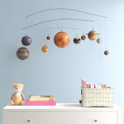 This solar system mobile educates your child while making sure they know they're the center of your universe. It measures about 20'' wide, with a metal rod construction featuring four tiers of rotating spheres. Each paper ball is painted to look like one of The Milky Way's eight planets orbiting around the sun - plus Pluto, just to be inclusive. Easy-to-spot Earth shows us exactly where we are when annually circling the sun; which reminds us that this wall art makes a great birthday gift for any Solar System Light, Solar System Chandelier, Planet Room, Planet Mobile, Solar System Mobile, Space Mobile, Outer Space Planets, Paper Ball, Space Themed Nursery