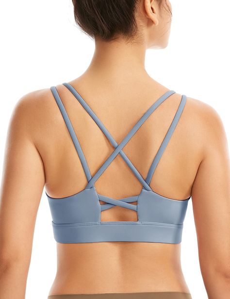 PRICES MAY VARY. WHY MADE THIS: The ultimate all-in-one sports bra! Our sweat-wicking cross-strap bra offers coverage and support for yoga, running, and the gym without restricting movement. Added lycra for stretch and shape retention. Optional, removable cups. Medium support for comfort. EXCEPTIONAL DESIGN: Stylish and functional! Crisscross back detailing, heat transfer tech, lined shelf bra, and soft performance fabric. Cotton-like material feels great. Twist with ease thanks to crisscross ba Cute Sports Bras, Cute Sports Bra, Strap Bra, Yoga Top, Padded Sports Bra, Yoga Bra, Kids Luggage, Yoga Tops, Bra Straps