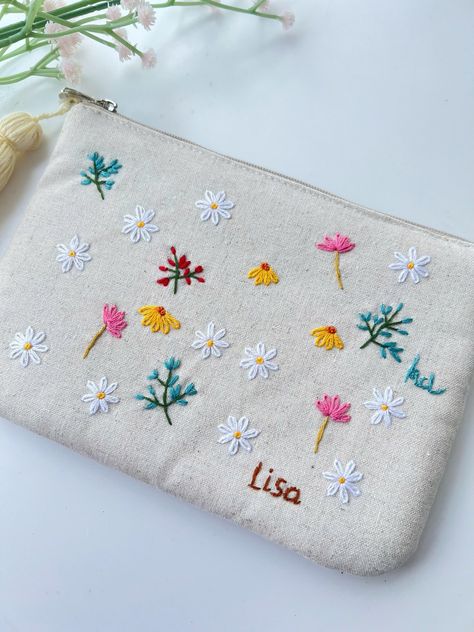 IF YOU NEED A PERSONALIZED DESIGN OR CUSTOM SIZE, PLEASE MESSAGE US. 📍 The pouch is embroidered with beautiful flowers, daisy and can be customed your names, completely hand-embroidered from Vietnamese craftsmen.  - Material: soft linen combined with embroidery floss - Texture: embroidered flowers and custom text.  - Size: 12x18cm The bag is not only cosmetic bag but can be served as an everyday bag for your sunglasses, headphones, cell phone, jewerly. 📍  You buy this for yourself or give it a Useful Embroidery Gifts, Embroidered Coin Purse, Embroidered Makeup Bag, Embroidery Gifts For Friends, Embroidered Bags Diy, Hand Embroidered Tote Bag, Purse Embroidery, Hand Embroidered Gifts, Embroidered Pouch