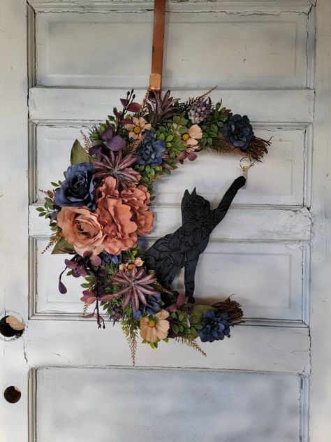 "Witchy Crystal Wildflower Cat Crescent Moon Front Door Wreath * Boho Botanical Celestial Hanger * Cottagecore Decor * Mom Cat Lovers Gift For the girls with stars in their eyes and wildflowers (with a little cat hair) in their hair! This 18\" grapevine moon is bursting with beautiful, natural looking greenery and flowers and an authentic smokey quartz hanging crystal. The 12\" kitty is uniquely patterned. This wildflower wreath makes a fabulous gift for any plant enthusiast. I only create my wr Front Door Witch Decor, Black Cat Wreaths For Front Door, Hanging Door Decor, Cottage Core Wreath, Witchcore Home Decor, Boho Wreaths For Front Door Spring, Decor Above Door, Moon Front Door, Witchy Decor Witch Cottage