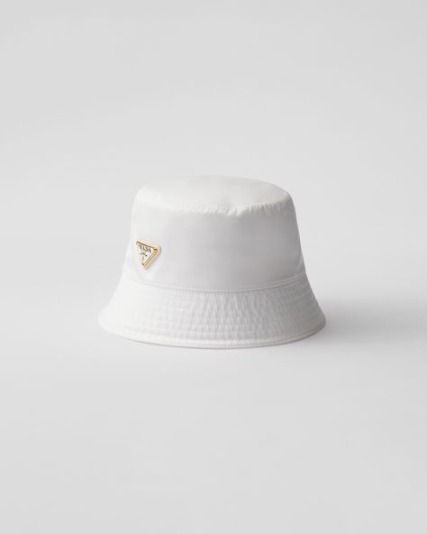 This bucket hat, an iconic accessory of Prada collections, is made of Re-Nylon: regenerated nylon yarn (ECONYL®)produced from recycled, purified plastic trash collected in the ocean, fishing nets and textile waste fibers. For sustainable care to preserve the product's characteristics and reduce microfiber shedding, we recommend not washing the item too often. Let the product air out after every use and have it dry cleaned at a specialized ecological dry cleaners. White Bucket Hats, Re Edition Prada, Prada Hat, Plastic Trash, Bucket Hat White, Textile Waste, Prada Collection, Ballerina Slippers, Luggage Bags Travel