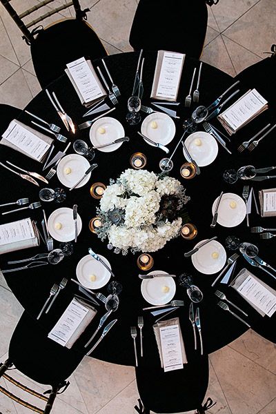 Think you can't use black as a primary wedding color? Think again. When paired with white, the effect is so timeless that you'll still love looking at your photos decades from now. Elegant Black Table Decor, Centerpieces For Black Tablecloth, Modern Romantic Wedding Reception, Wedding Tablescapes Black Tablecloth, Black Table Cloth Centerpiece, Black Tablecloth Decor Wedding, Black Tablecloth White Flowers, Black Linen Table Setting, Wedding Tables With Black Tablecloths