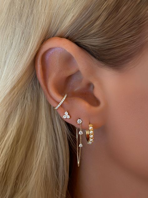 Enhance your look with our Trio Flower Cluster Stud Earrings. These pretty studs feature a trio of delicate flowers, each with a subtle sparkle, perfect to wear in your ear lobe and cartilage. Styled on our model, Hailey with Vermeil Spike Dagger Drop Huggie EarringsStyled on our founder, Emily withVermeil Pearl HuggiesFine White Topaz Dangle Chain Stud Earrings Size: 4mm ClusterStone: Cubic ZirconiaMaterials: Sterling Silver & 14K Gold Vermeil Earrings For 4 Holes, Four Earrings Piercings, Multiple Ear Piercings Small Ears, Lobe Earrings Triple, 3 Ear Lobe Piercings In A Row, Earring Stack 3, 3 Pericing Ideas, Gold And Silver Earrings Combo, Upper Helix Piercing Studs