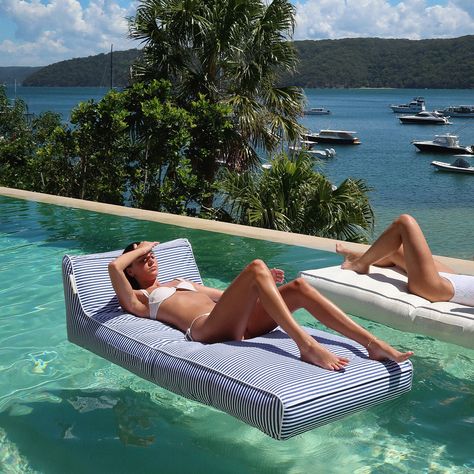 LUXURY MEETS LEISURE Experience the best of summer where luxury meets leisure. The Le Weekend Luxe Lie-On Lounger is stylish, oversized, and the CEO of relaxation, perfect for floating in the pool and long balmy days spent by the seaside. Designed in an easy-to-lie-on shape with head and shoulder support, side handles, and with its luxurious size, floating has never been so effortlessly comfortable. Take delight in the simple pleasures and have twice the fun with its vintage stripe print and nau Pool House Must Haves, Aesthetic Pool Floats, Pool Furniture Ideas Decor, Floaties For The Pool, Pool Floats Aesthetic, Pool Side Decorating Ideas, Pool Necessities, Pool Furniture Ideas, Merica Monday