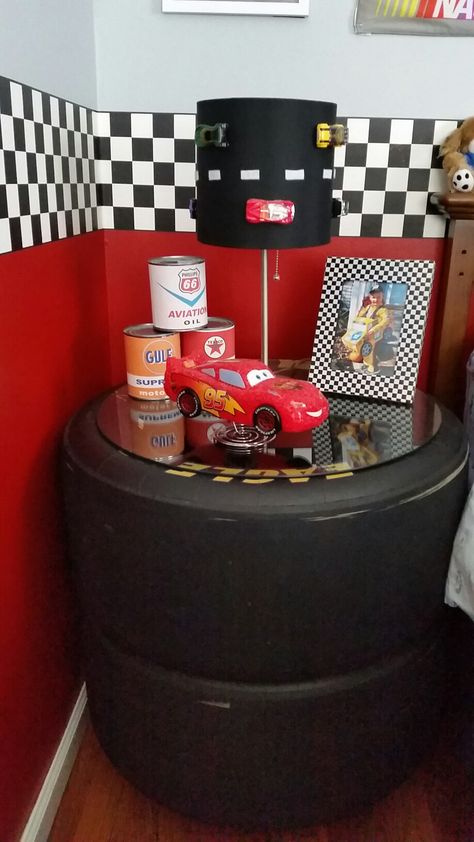 Night stand made from race car tires. Race Car Playroom, Racing Decorations House, Race Car Theme Room, Race Car Bathroom Ideas, Nascar Tire Ideas, Cars Themed Bedroom Toddler, Race Car Bedroom Decor, Nascar Bedroom Ideas, Boys Race Car Bedroom Ideas