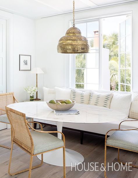 In this breakfast nook, a vintage brass beehive chandelier provides a hit of warmth even during the day. | Photographer: Jessica Glynn | Designer: Ashley Waddell and Courtney Whatley Banquette With Oval Table, Modern Breakfast Nook, Banquette Dining, Saarinen Table, Dining Banquette, Kitchen Banquette, Cozy Breakfast Nook, Banquette Seating, Versace Home