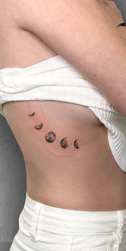 << Check out more Moon Phase Tattoos, Ideas and Meanings #tattoomenow #tattooideas #tattoodesigns #tattoos #Moonphase #Moonphasetattoo Moon Phase Tattoo Ribs, Moon Phase Back Tattoo Women, Luna Eclipse Tattoo, Moon Changes Tattoo, Ribcage Moon Tattoo, Stages Of The Moon Tattoo, Women Ribcage Tattoo, Moonphase Tattoo Design, Spine Tattoos For Women Moon Phases