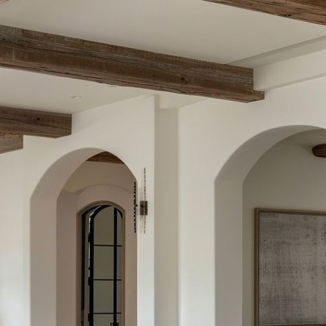 New Mode Home on Instagram: "Elevate your home by incorporating standout architectural elements that boost aesthetic appeal and add value and character. Reclaimed wood beams add a touch of rustic warmth and charm, while arched doorways create graceful transitions between spaces.   AI Render by @newmodehome   •••  Follow @newmodehome for more design inspiration and tips.  #HomeImprovement #WoodBeams #ArchedDoorways #InteriorDesignTips #HomeEnhancement #myNMH" Arch In Living Room, Arched Doorways Interior, Arched Hallway, Archways In Homes, Arched Opening, Arched Doorway, Arched Doorways, Reclaimed Wood Beams, Arch Doorway