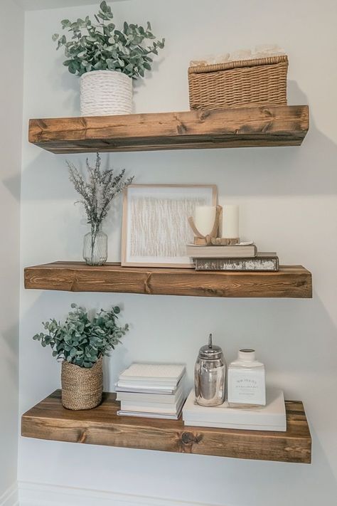 Use floating shelves to display aesthetically pleasing decor like candles, books, plants, and small framed art. To maintain a minimalist look, style the shelves with a limited number of items and ensure each piece complements the others in color and style. Great for living rooms, bedrooms, or kitchens.🛋✨ #FloatingShelves #StyledShelves #MinimalistDecor Wall Shelf Living Room Decor, Decorations For Floating Shelves, Floating Shelves Placement Ideas, Shelf Decor Living Room Wall Shelves, Floating Shelves Arrangement, White Floating Shelves Living Room, Floating Shelf Decor Bedroom, Kitchen Floating Shelves Decor Ideas, Floating Shelf Decor Living Room