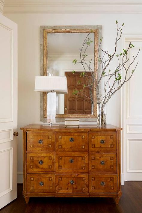 Chic foyer features a gray and gold mirror placed over a 9 drawer chest topped with a vase full of branches. Entryway Chest, Collins Interiors, Apothecary Style, Console Table Decorating, Foyer Decor, Foyer Decorating, White Chic, Foyer Design, Space Decor