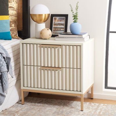 A clean-lined nightstand like this one takes a unique vintage style and makes it effortlessly mod. It rests on straight metal corner legs, while the rest of the piece is engineered wood in a muted tone. The two drawer fronts feature fluted details and metal hardware, making it easy to tuck away all your bedtime essentials. Measuring just over 22" wide, this bedside table fits neatly next to your bed or living room sofa. Color (Top/Base): Bleached White | Joss & Main Burgess 2 - Drawer Nightstand Side Tables Bedroom Modern, Unusual Bedside Tables, Nyc Room, Stylish Nightstand, Bedside Essentials, Safavieh Furniture, Bedside Table Design, Modern Bedside Table, White Nightstand