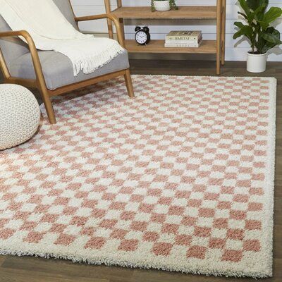 This area rug sets a foundation for your bedroom with an abstract motif and style. It's power-loomed from polypropylene, and it has a playful checker print in blush pink and cream hues. it's best for lower-traffic areas, such as your bedroom or home office. Best of all, this rug is stain-resistant, so it stands up to regular use. They recommend pairing it with a rug pad to keep it in place underfoot. | AllModern Walker Checkered Pink/Cream Shag Area Rug Pink/White 1.18 in | C007390946_1627744256 Abstract Motif, Area Rug Sets, Living Room Area, Checkered Rug, Checker Print, Pink Area Rug, Shag Area Rug, Geometric Area Rug, Rug Sets